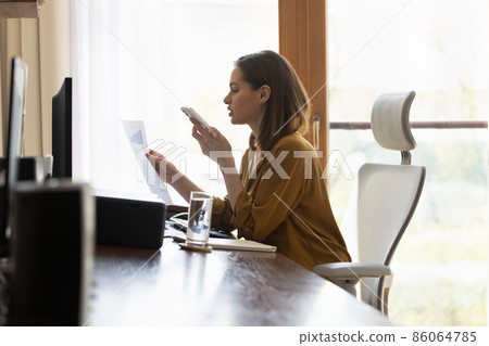 Busy professional woman negotiating on startup project financial report Busy professional woman negotiating on startup project financial report 86064785