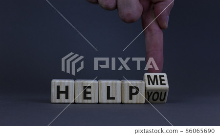 Help you or me symbol. Businessman turns a cube and changes words help me to help you. Beautiful grey table, grey background, copy space. Business, motivational and help you or me concept. 86065690