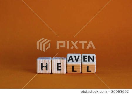 Hell or heaven symbol. Turned wooden cubes and changed the word 'hell' to 'heaven'. Business and religion concept. Beautiful orange background, copy space. 86065692