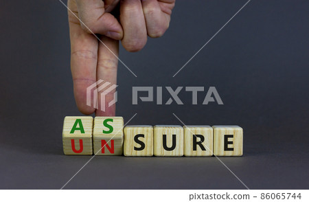 Assure or unsure symbol. Businessman turns wooden cubes and changes the concept word unsure to assure. Beautiful grey table, grey background, copy space. Business and assure or unsure concept. Assure or unsure symbol. Businessman turns wooden cubes and changes the concept word unsure to assure. Beautiful grey table, grey background, copy space. Business and assure or unsure concept. 86065744