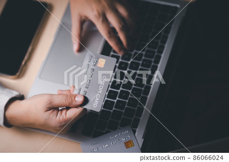 Hand holding credit card and using laptop. Businessman or entrepreneur working from home. Online shopping, e-commerce, internet banking, spending money, work from home concept. Internet online banking Hand holding credit card and using laptop. Businessman or entrepreneur working from home. Online shopping, e-commerce, internet banking, spending money, work from home concept. Internet online banking 86066024