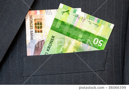 Banknotes of Norwegian krones sticking out of the business suit pocket 86066399
