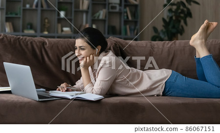 Smiling millennial Indian woman watching educational lecture. 86067151
