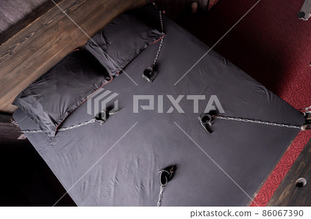 BDSM Leather handcuffs for role-playing games on a gray sheet. Bondage for carnal pleasures. Domination and submission. BDSM Leather handcuffs for role-playing games on a gray sheet. Bondage for carnal pleasures. Domination and submission. 86067390