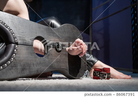 Female hands in wooden shackles during role-playing games. Shameful pillar and leather cuffs for sex. BDSM Domination and punishment. Female hands in wooden shackles during role-playing games. Shameful pillar and leather cuffs for sex. BDSM Domination and punishment. 86067391