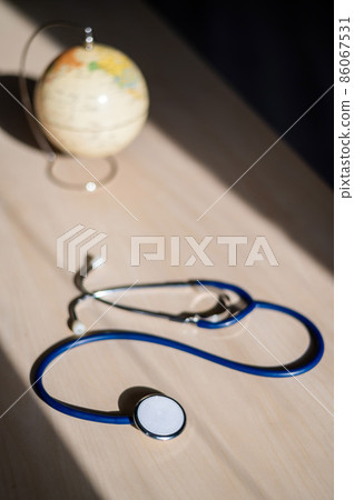 Globe and stethoscope. The concept of global warming and pollution. Phonendoscope and earth miniature. Stethophonendoscope. 86067531