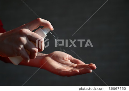 Female hands applying alcohol antibacterial spray to prevent the spread of germs, bacteria and viruses. Personal hygiene concept during the period of the respiratory disease epidemic. 86067560