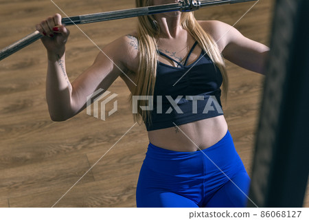 Sporty woman doing thrust of upper block to chest. Girl doing workout exercise with thrust of Pulldown. Sporty woman doing thrust of upper block to chest. Girl doing workout exercise with thrust of Pulldown. 86068127