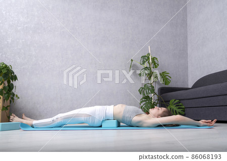 Young yogi woman practicing yoga with foam block. Stretching in dvi pada pithasana exercise. Yoga at home. Young yogi woman practicing yoga with foam block. Stretching in dvi pada pithasana exercise. Yoga at home. 86068193