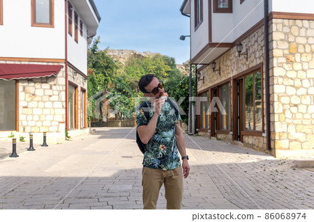 tourist eat ice cream on the street of an mediterranean town tourist eat ice cream on the street of an mediterranean town 86068974