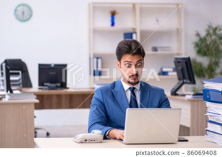Young businessman employee unhappy with excessive work in the of Young businessman employee unhappy with excessive work in the of 86069408