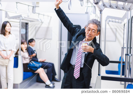 Middle-aged man drinking on the train Middle-aged man drinking on the train 86069884