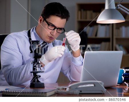 Young doctor working late in the office Young doctor working late in the office 86070346