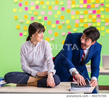 Man and woman in the office with many conflicting priorities in Man and woman in the office with many conflicting priorities in 86070786