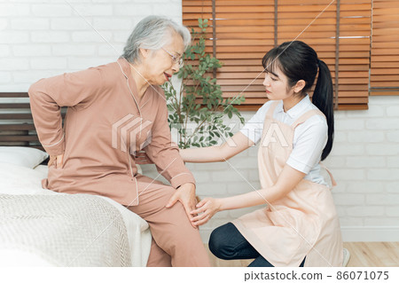 Elderly female who hurts and female in an apron (backache) 86071075