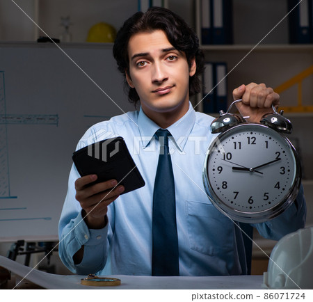 The young male architect working night at office The young male architect working night at office 86071724