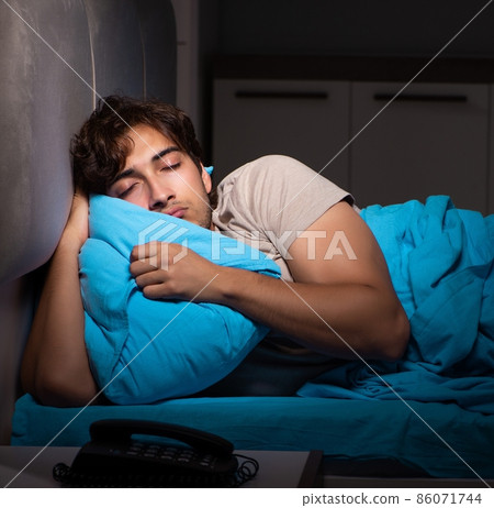 The tired exhausted man sleeping in his bed The tired exhausted man sleeping in his bed 86071744