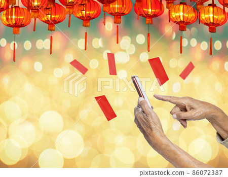 Grandmother hand giving a red envelope or hongbao via cell phone to kids on chinese new year celebration. Grandmother hand giving a red envelope or hongbao via cell phone to kids on chinese new year celebration. 86072387