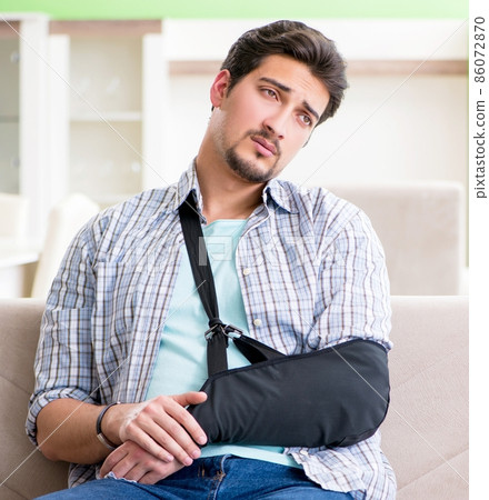 Young student man with hand injury sitting on the sofa Young student man with hand injury sitting on the sofa 86072870