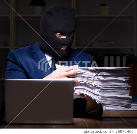 Male employee stealing information in the office night time 86073463