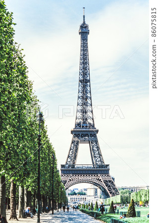 Eiffel Tower seen through the trees from the Champ de Mars Park 86075815