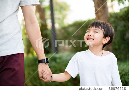 A little boy playing with his father at a park. A little boy playing with his father at a park. 86076218