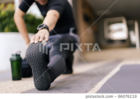 Active Asian sportsman making a stretching before exercise. Active Asian sportsman making a stretching before exercise. 86076219