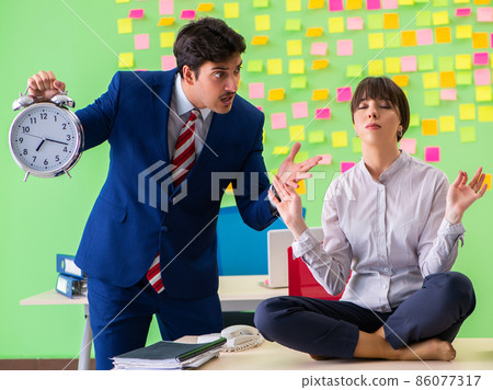Man and woman in the office with many conflicting priorities in 86077317