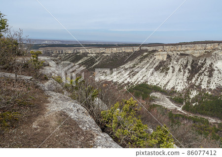 View of valley and mountain Besh-Kosh from plateau Burunchak near cavetown Chufut-Kale. Bakhchysarai, Crimea View of valley and mountain Besh-Kosh from plateau Burunchak near cavetown Chufut-Kale. Bakhchysarai, Crimea 86077412