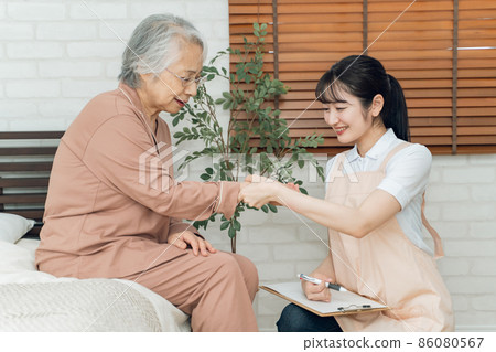 測量老年婦女脈搏的女性工作人員 86080567