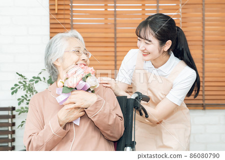 Elderly female given a bouquet 86080790