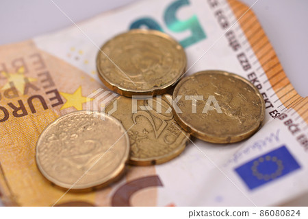 Closeup on EURO paper money note with four 20 cent coins Closeup on EURO paper money note with four 20 cent coins 86080824