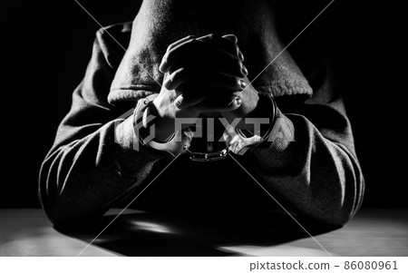 Arrested criminal hands locked in handcuffs. 86080961