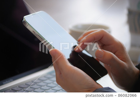 A woman operating a smartphone 86082066