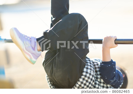 Girl practicing horizontal bar Girl practicing horizontal bar 86082465