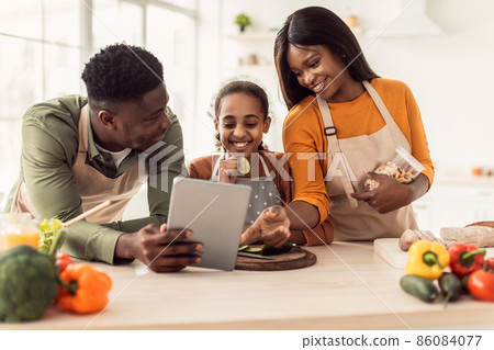 Black Family Cooking Using Digital Tablet Preparing Dinner In Kitchen Black Family Cooking Using Digital Tablet Preparing Dinner In Kitchen 86084077