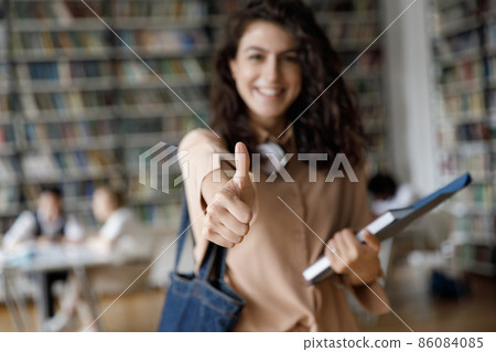 Happy satisfied college girl making thumb up, showing like Happy satisfied college girl making thumb up, showing like 86084085