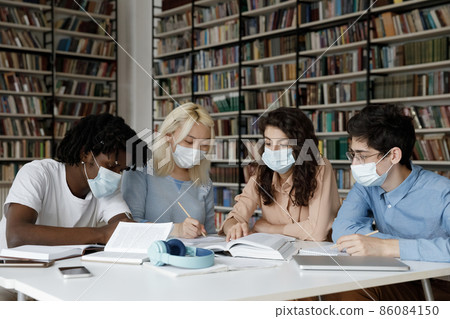 Diverse college students in protective medical masks writing notes Diverse college students in protective medical masks writing notes 86084150