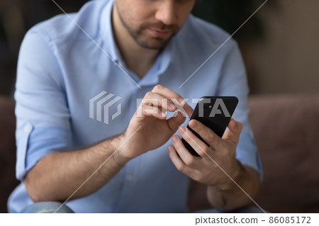 Cropped close up man using smartphone, typing on screen 86085172
