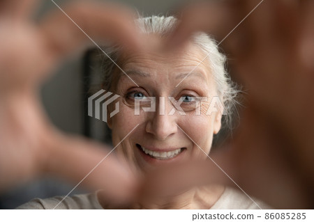 Happy beautiful middle aged old retired woman making heart symbol. Happy beautiful middle aged old retired woman making heart symbol. 86085285
