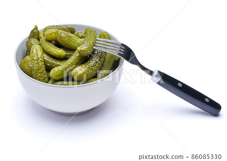 Plate of Tasty canned Whole green cornichons isolated on a white background 86085330