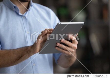 Crop close up man using modern tablet, typing on screen 86085505