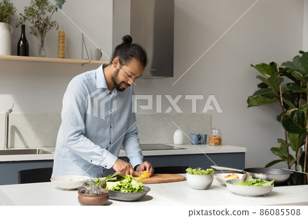 Focused young African American chef guy preparing vegan dinner alone 86085508