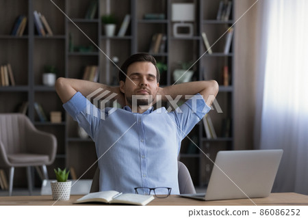 Calm businessman leaning back in office chair during break 86086252