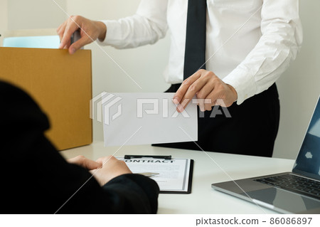 Desperately fired man office worker employee hands her employer her resignation letter and packs her belongings in a cardboard box concept dismissal and unemployment Desperately fired man office worker employee hands her employer her resignation letter and packs her belongings in a cardboard box concept dismissal and unemployment 86086897