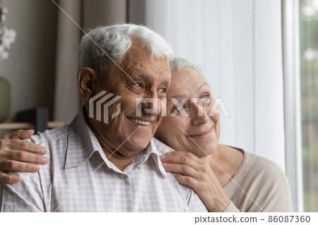 Happy dreamy bonding old couple looking in distance. 86087360