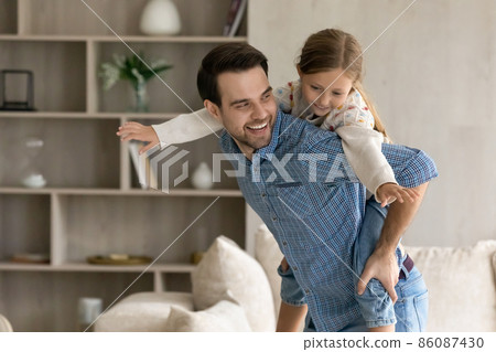 Happy father holding on back cute daughter. Happy father holding on back cute daughter. 86087430