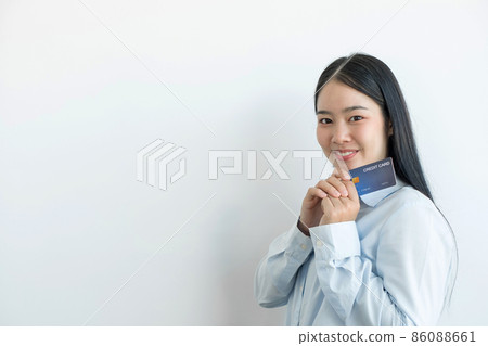 The hand of an Asian woman holding a credit card is used for online shopping and Internet payments 86088661