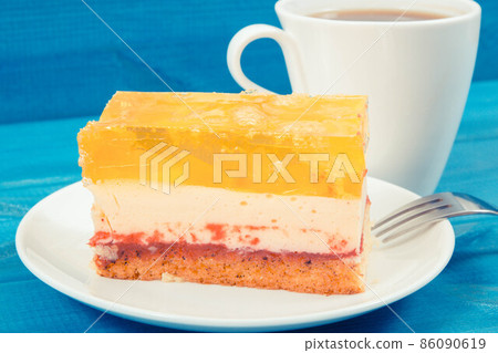 Creamy fruit cake with jelly and cup of coffee for different occasions. Festive dessert 86090619