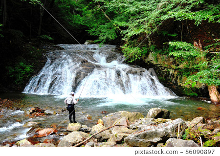 Angler fishing in the basin of Marga Falls 86090897
